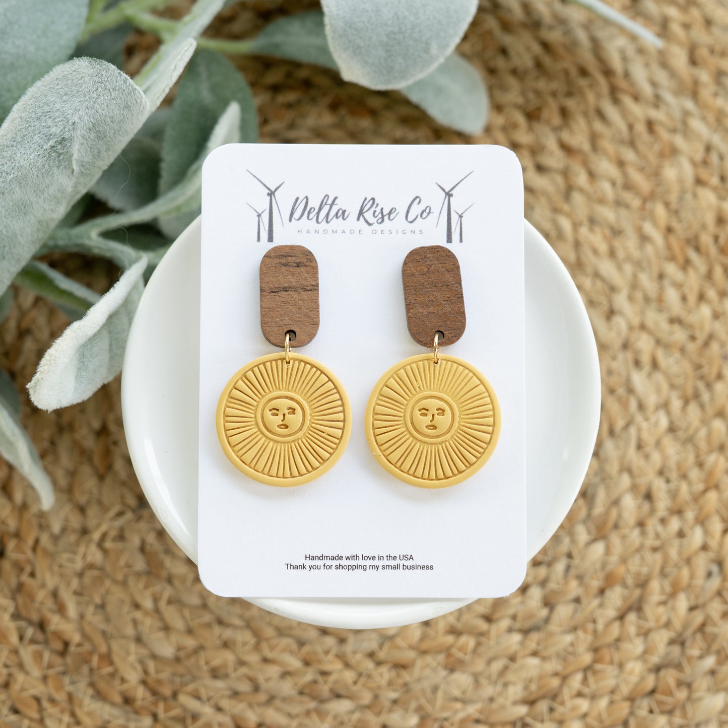 Handmade polymer clay sun earrings in a warm golden mustard color featuring natural wooden top accents for a rustic boho look. These lightweight statement earrings are designed for comfortable all-day wear while adding an earthy and artistic touch to any outfit. Inspired by western style, desert tones, and sunburst designs, they pair beautifully with denim, dresses, sweaters, and casual everyday looks. Perfect for festivals, boutiques, farmers markets, country events, or gifting, these handcrafted earrings