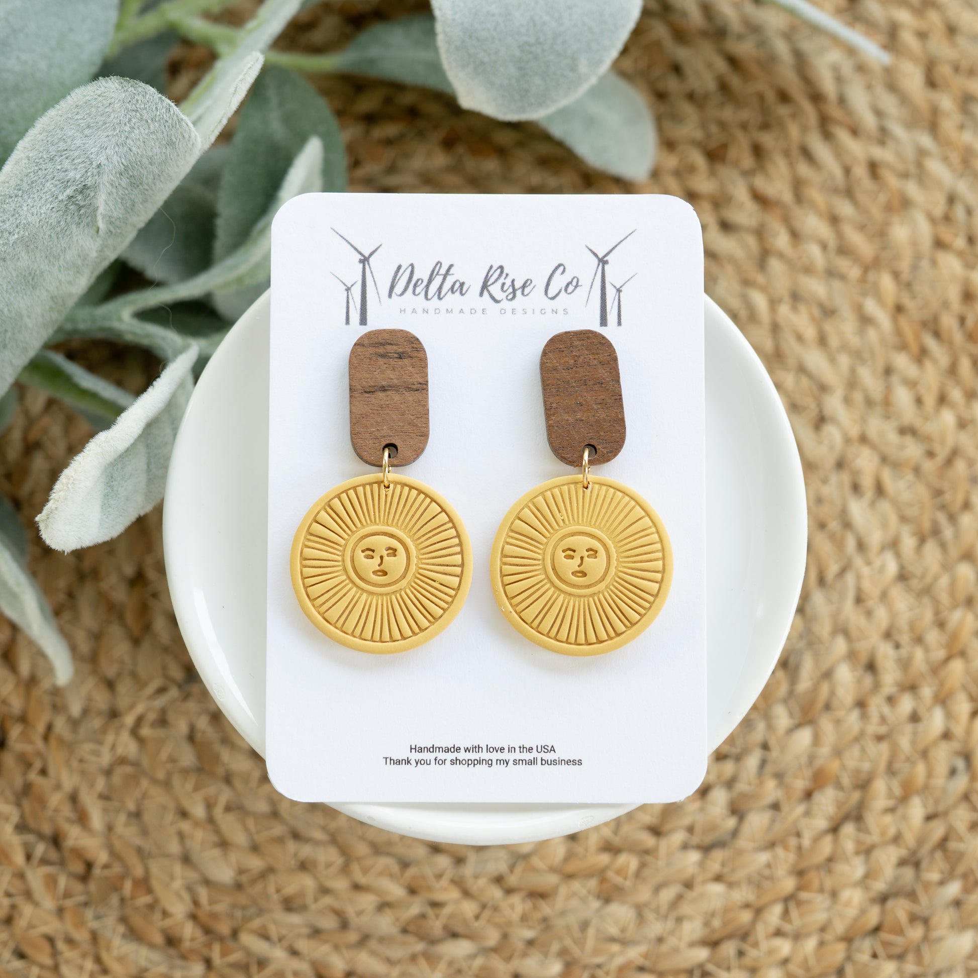 Handmade polymer clay sun earrings in a warm golden mustard color featuring natural wooden top accents for a rustic boho look. These lightweight statement earrings are designed for comfortable all-day wear while adding an earthy and artistic touch to any outfit. Inspired by western style, desert tones, and sunburst designs, they pair beautifully with denim, dresses, sweaters, and casual everyday looks. Perfect for festivals, boutiques, farmers markets, country events, or gifting, these handcrafted earrings 