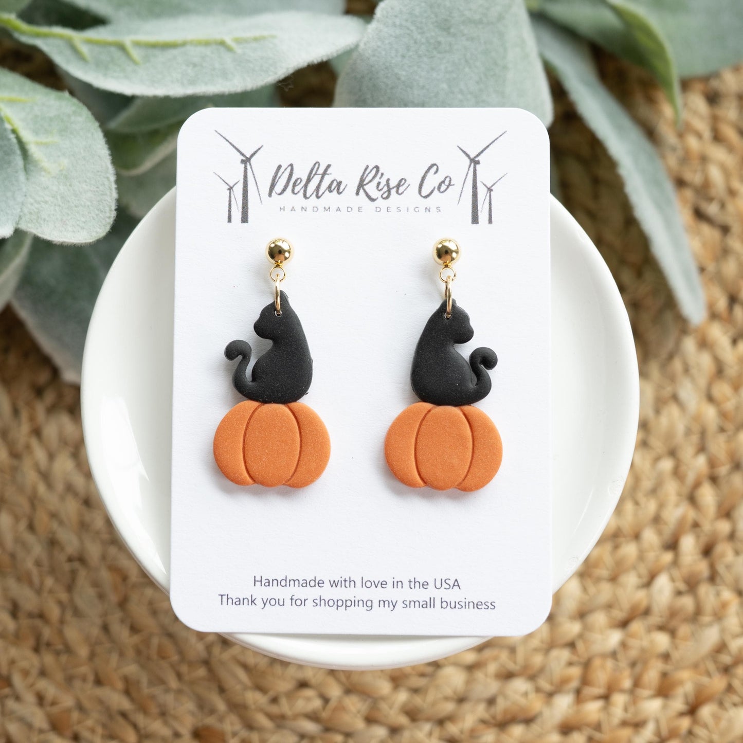 Handmade clay earrings featuring a black cat sitting on a bright orange pumpkin, perfect for Halloween and fall fashion. These lightweight polymer clay earrings combine spooky charm with seasonal style, making them a fun accessory for Halloween parties, autumn outfits, or gifts for cat lovers. Unique handmade jewelry designed to bring a playful and festive touch to your fall accessories.