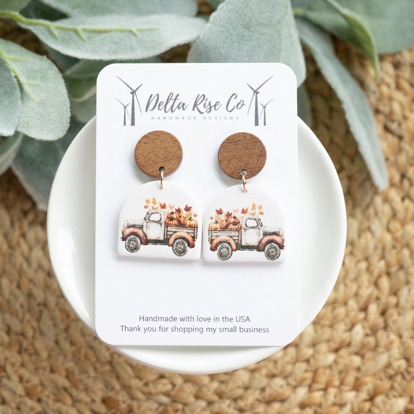 Handmade fall truck earrings carrying leaves, perfect for autumn and Thanksgiving fashion. Lightweight polymer clay earrings feature a charming vintage truck filled with colorful fall leaves, adding festive and cozy charm to seasonal outfits, fall gatherings, or pumpkin patch visits. Unique handmade jewelry ideal for gifting or adding a playful, autumn-inspired touch to your seasonal wardrobe.