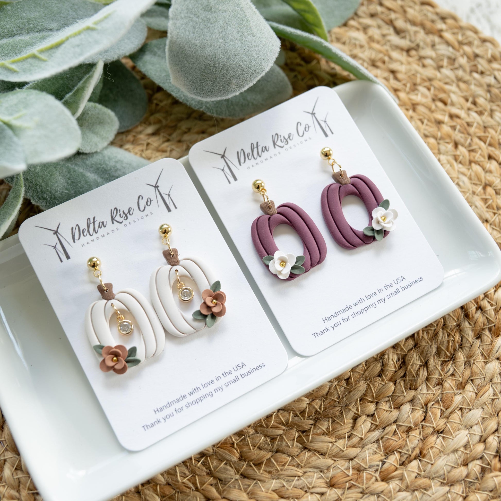 Handmade floral pumpkin earrings in plum or cream, with optional center charm, perfect for fall and autumn fashion. Lightweight polymer clay earrings feature delicate floral designs on pumpkin silhouettes, creating festive charm for Thanksgiving, autumn outfits, or seasonal gifting. Comfortable, unique, and handmade, these earrings add playful elegance and seasonal style to any autumn wardrobe.